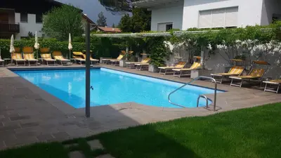 a swimming pool with lounge chairs at Hotel Maximilian in Merano