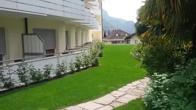 a yard with green grass next to a building at Hotel Maximilian in Merano