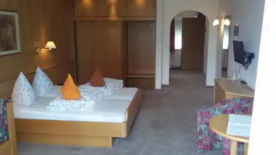 a room with a bed with orange pillows on it at Hotel Maximilian in Merano