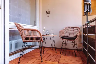 two chairs and a table in front of a window at Pool House Merano in Merano