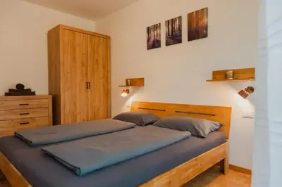a bedroom with a wooden bed and a wooden dresser at Pool House Merano in Merano
