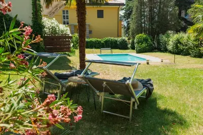 two chairs and a table and a swimming pool at Pool House Merano in Merano