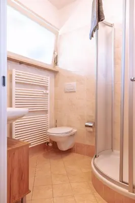 a bathroom with a toilet and a sink and a shower at Pool House Merano in Merano