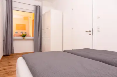a white bedroom with a bed and a window at Merano City Living in Merano