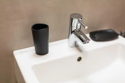 a black cup sitting on top of a white sink at Merano City Living in Merano