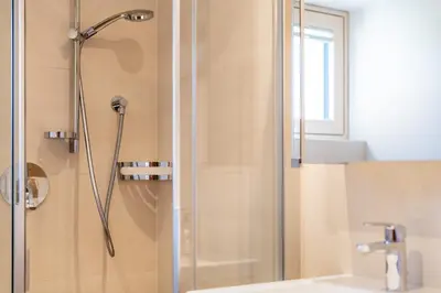 a bathroom with a shower and a sink at Stürz Ferienwohnungen in Termeno