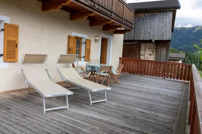 a deck with chairs and a table on a house at Unterwegerhof in Tires