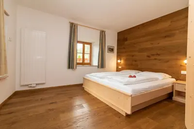 a bedroom with a bed with a wooden wall at Unterwegerhof in Tires