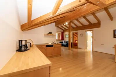 a kitchen and living room with wooden beams at Unterwegerhof in Tires