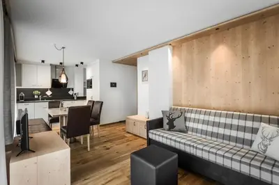 a living room with a table and a couch at Chalet Martina Apartments in San Vigilio Di Marebbe