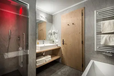a bathroom with a sink and a mirror at Chalet Martina Apartments in San Vigilio Di Marebbe