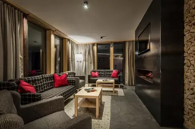 a living room with a couch and a kitchen at Chalet Martina Apartments in San Vigilio Di Marebbe