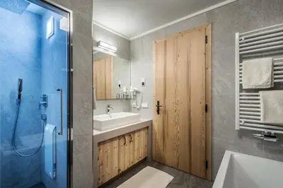a bedroom with a white bed and a window at Chalet Martina Apartments in San Vigilio Di Marebbe