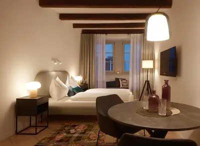 a hotel room with a bed and a table at Binder Apartment in Bolzano