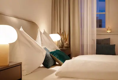 a hotel room with a bed with white sheets and pillows at Binder Apartment in Bolzano