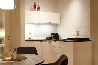 a kitchen with a table and chairs and a counter at Binder Apartment in Bolzano