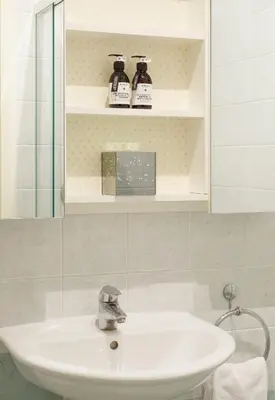 a bathroom with a white sink and a mirror at Binder Apartment in Bolzano