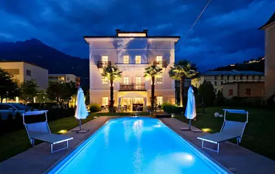 a house with a swimming pool in front of a house at Garni Villa Tyrol - Adults Only in Merano