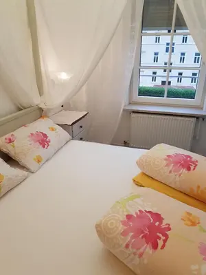 a bedroom with a bed with two pillows and a window at Garni Villa Tyrol - Adults Only in Merano