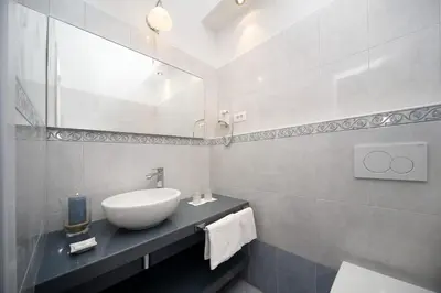 a white bathroom with a sink and a mirror at Garni Villa Tyrol - Adults Only in Merano