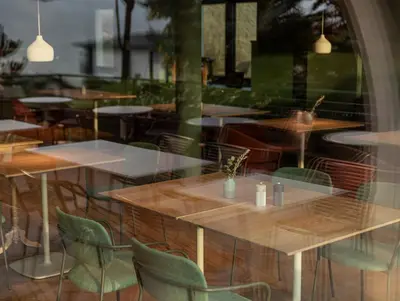 a reflection of tables and chairs in a window at Pension Höfler - Fernblick in Schenna