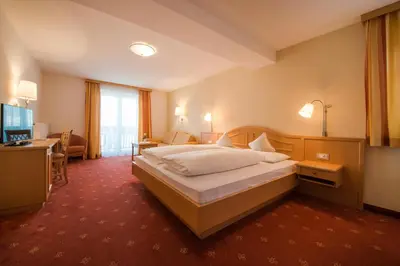 a hotel room with a bed and a television at Pension Höfler - Fernblick in Schenna