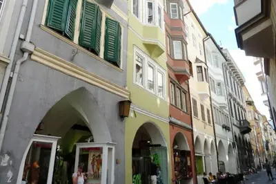 a building with green shutters on a city street at Lauben Apartment Bolzano in Bolzano