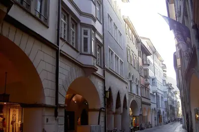 a city street with buildings and an alley with a flag at Lauben Apartment Bolzano in Bolzano