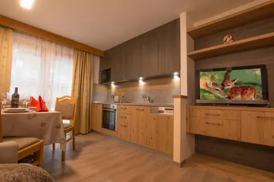 a bedroom with a red bed with a picture on the wall at Residence Villa Artic in Campitello di Fassa