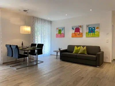 a living room with a couch and a table at Neu, zentral, sonnig, Garage inklusive in Merano