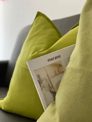 a book sitting on top of a green pillow at Neu, zentral, sonnig, Garage inklusive in Merano