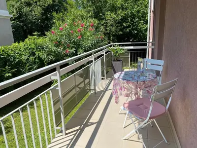 a patio with a table and chairs on a balcony at Neu, zentral, sonnig, Garage inklusive in Merano