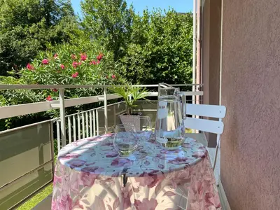 a table with wine glasses on a balcony at Neu, zentral, sonnig, Garage inklusive in Merano