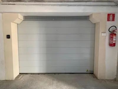 a white garage door with a fire hydrant in it at Neu, zentral, sonnig, Garage inklusive in Merano
