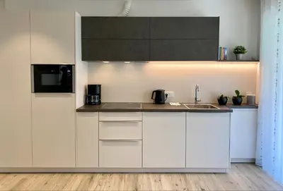 a kitchen with white cabinets and a sink at Neu, zentral, sonnig, Garage inklusive in Merano
