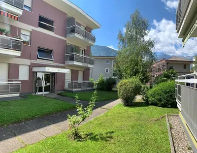 a pink apartment building with a yard at Neu, zentral, sonnig, Garage inklusive in Merano