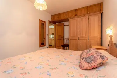 a bedroom with a bed with a pillow on it at Ciasa Molino 306 in Falcade