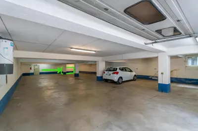 a parking garage with a white car parked in it at Ciasa Molino 306 in Falcade