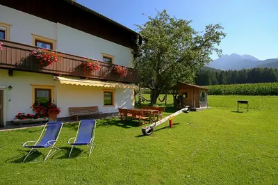 a house with two chairs and a cannon in the yard at Ferienwohnungen Bulandhof in Valdaora