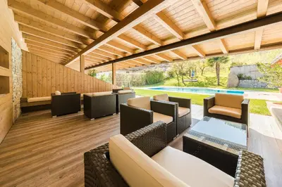 an outdoor patio with chairs and tables and a pool at Oberwirtshof in Rifiano