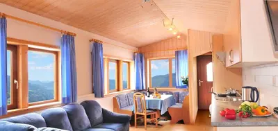a living room with a blue couch and a table at Rastlhof in Meltina