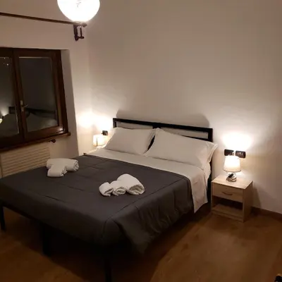 a bedroom with a bed with two towels on it at Hotel TEA DOLOMITI - Lago di Alleghe - Monte Civetta in Alleghe