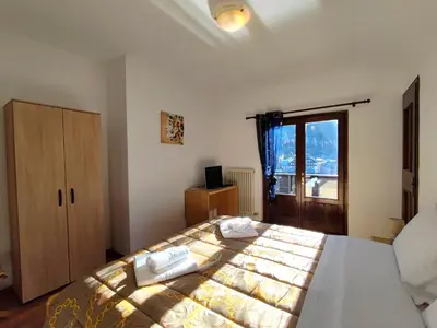 a bedroom with a bed with two towels on it at Hotel TEA DOLOMITI - Lago di Alleghe - Monte Civetta in Alleghe