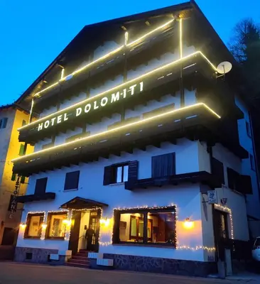 a hotel doolinium with lights on the side of it at Hotel TEA DOLOMITI - Lago di Alleghe - Monte Civetta in Alleghe
