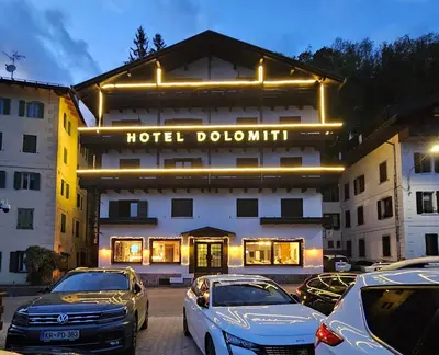 a hotel building with cars parked in front of it at Hotel TEA DOLOMITI - Lago di Alleghe - Monte Civetta in Alleghe