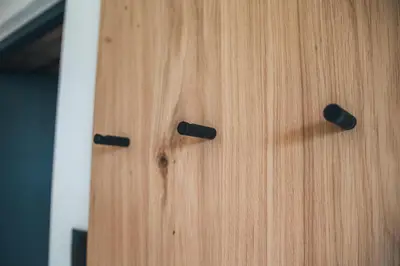 a wooden door with two black knobs on it at Aparthotel Bacher in Bressanone