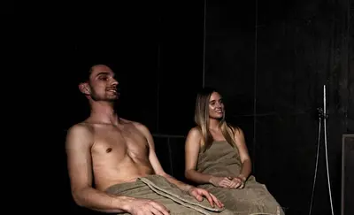 a man and a woman sitting in a shower at Aparthotel Bacher in Bressanone