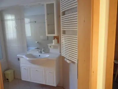a white bathroom with a sink and a mirror at Villa Bernhard in Siusi