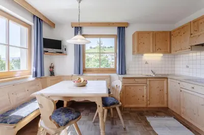 a kitchen with a wooden table and chairs and a sink at Villa Bernhard in Siusi