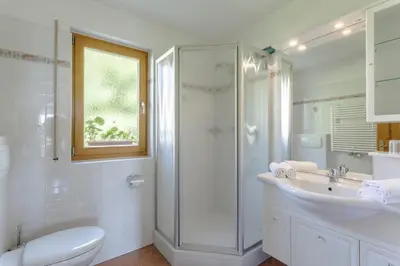 a bathroom with a shower and a toilet and a sink at Villa Bernhard in Siusi